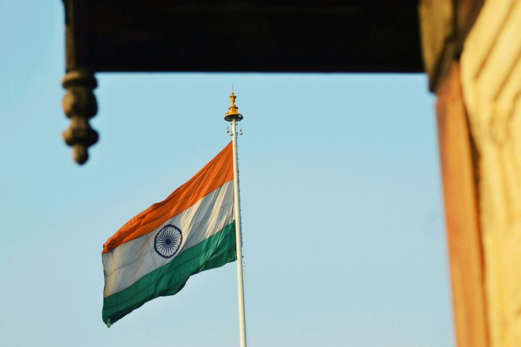 Indian national flag waving proudly against a clear blue sky, symbolizing patriotism.